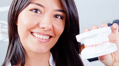 Woman holding up a mold of teeth